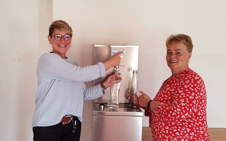 Zwei Mitarbeiterinnen der Kita testen den neuen Trinkwasserspender